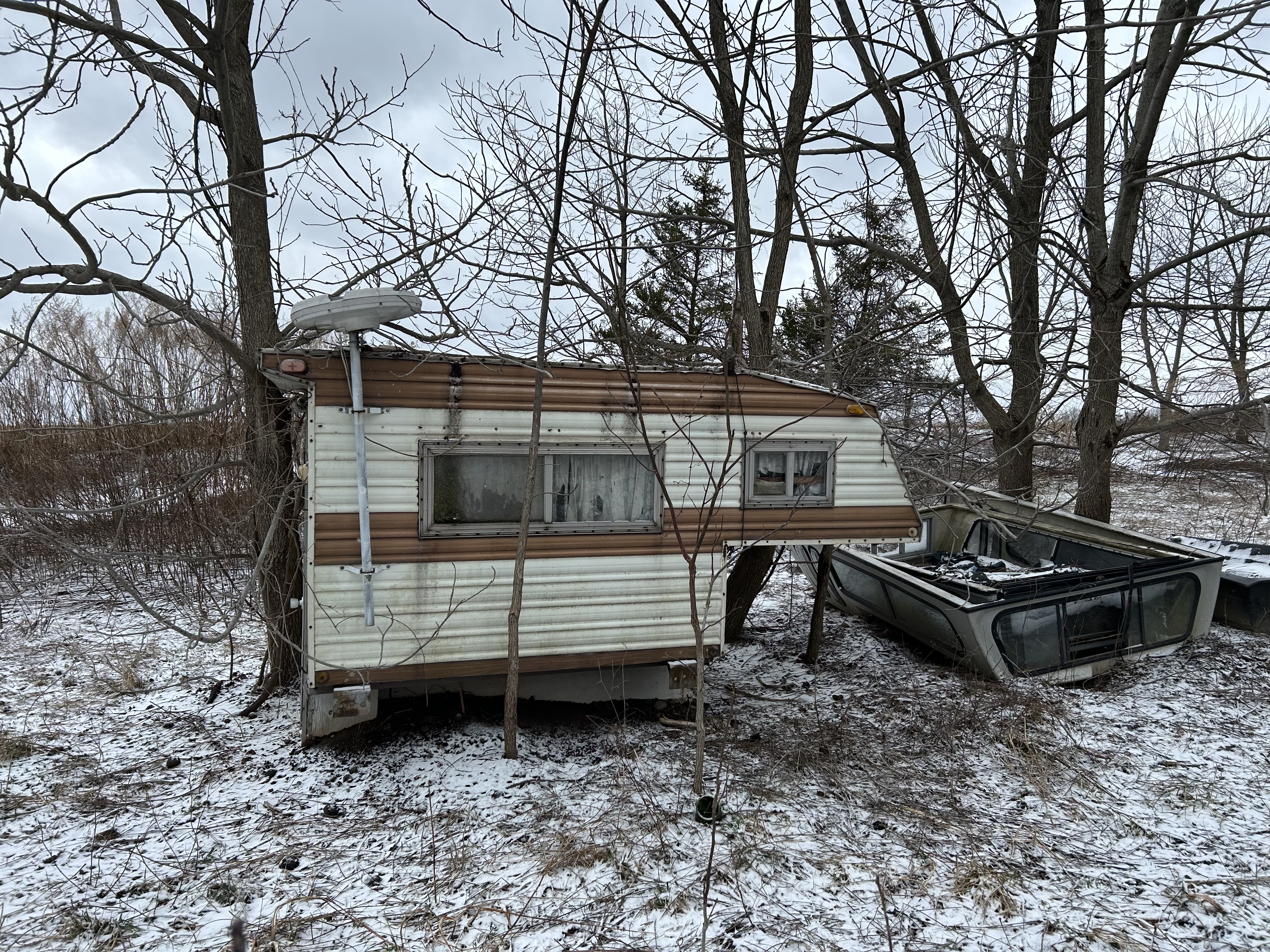 Camper that goes on the bed of a pickup truck. Been in back field for years. Town wants it gone.
