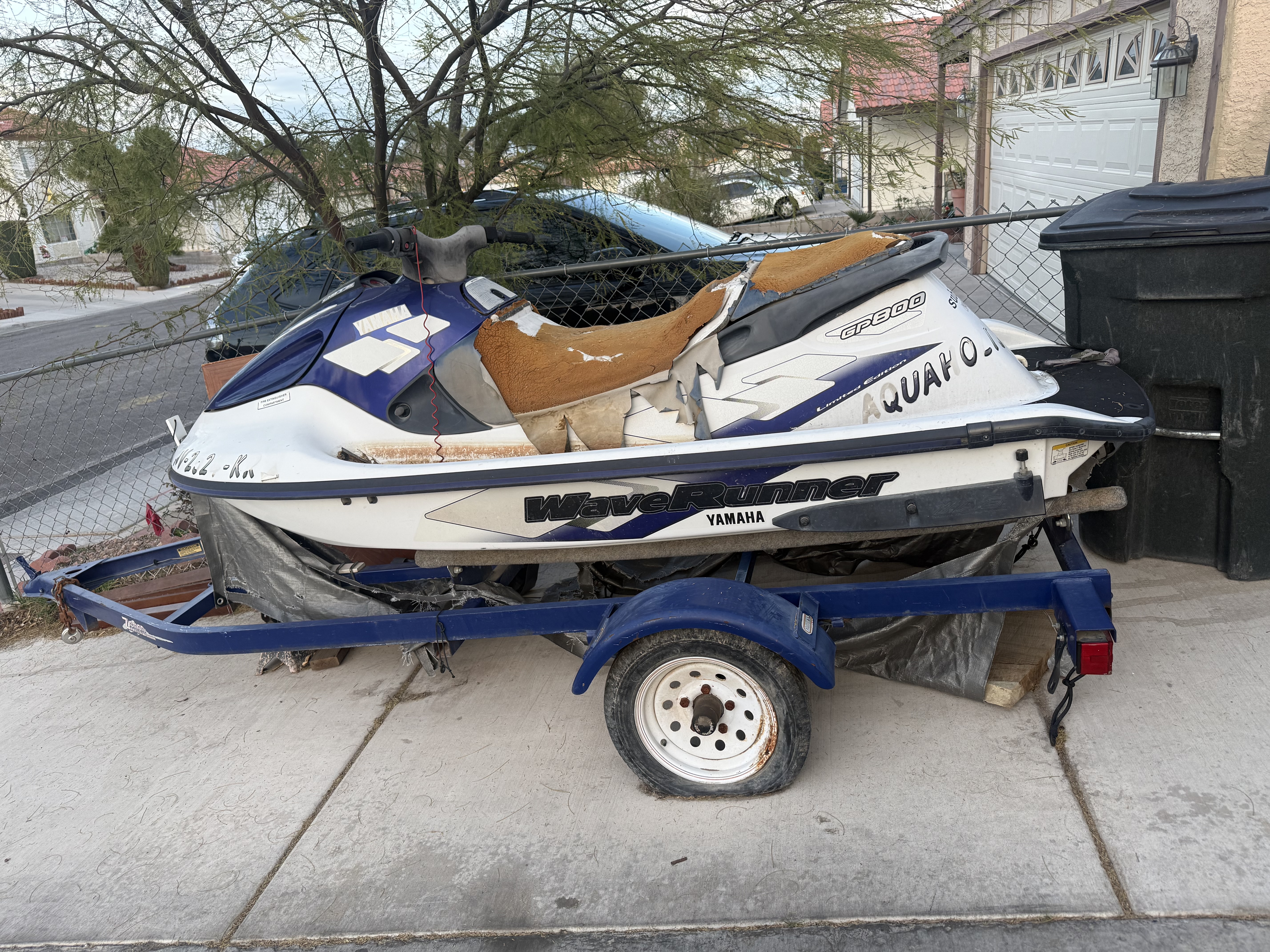 Inoperable jet ski on a trailer with flat tires. It's more than 25 years old and was supposed to be repossessed in a bankruptcy more than 20 years ago, but they never came to get it; as such, we have