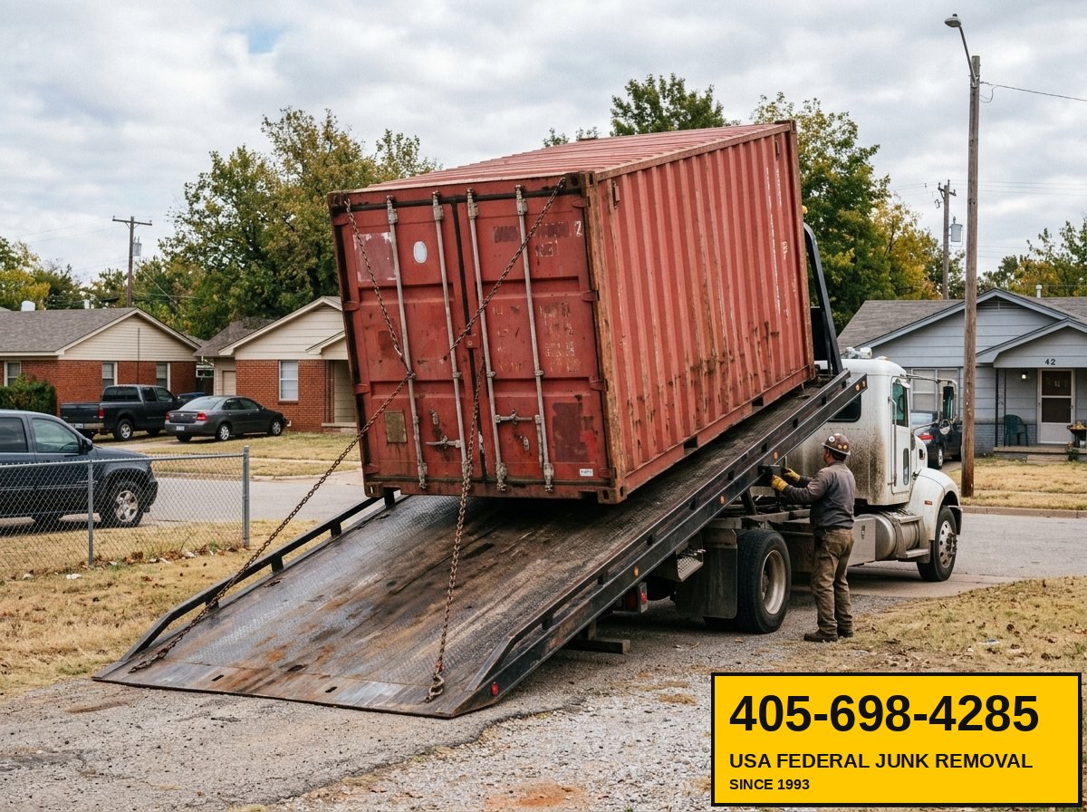 20-foot shipping container being extracted by tilt-bed tow rig from residential property